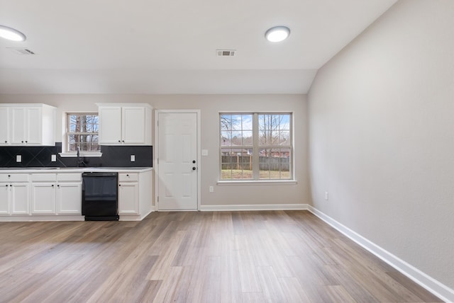 kitchen with lofted ceiling, dishwasher, white cabinets, and light hardwood / wood-style floors