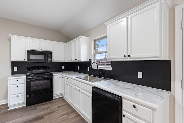 kitchen featuring sink, white cabinetry, black appliances, and vaulted ceiling