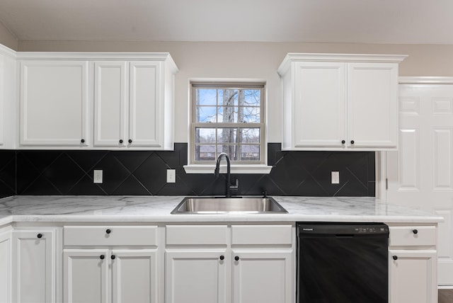 kitchen featuring backsplash, sink, white cabinetry, and black dishwasher