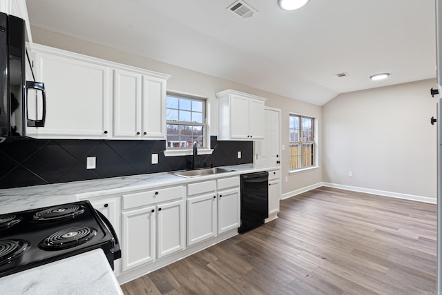 kitchen with white cabinetry, sink, lofted ceiling, light hardwood / wood-style flooring, and black appliances