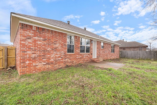 back of property featuring a lawn and a patio