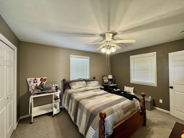 carpeted bedroom with ceiling fan, a textured ceiling, and a closet