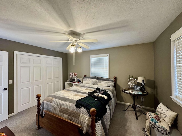 carpeted bedroom featuring ceiling fan, a textured ceiling, and a closet