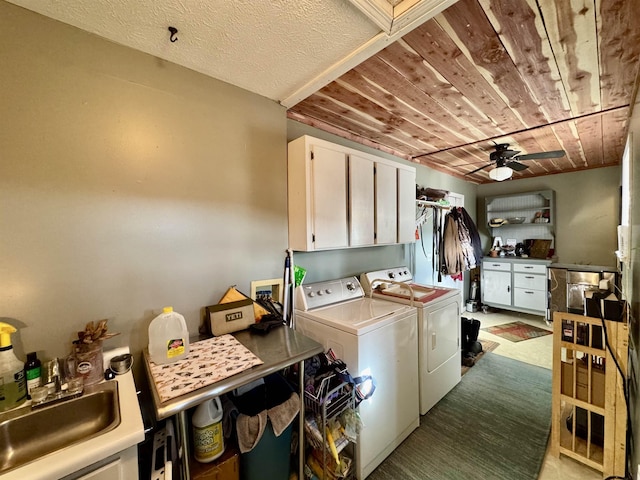 laundry room with wood ceiling, washer and clothes dryer, ceiling fan, cabinets, and sink