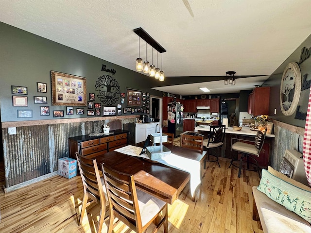 dining space with a textured ceiling and light hardwood / wood-style flooring