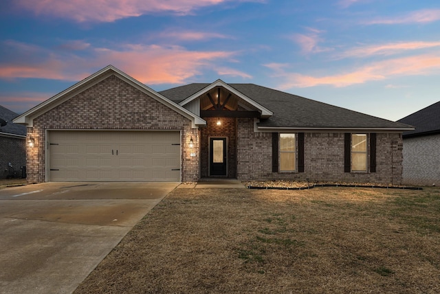 single story home featuring a lawn and a garage