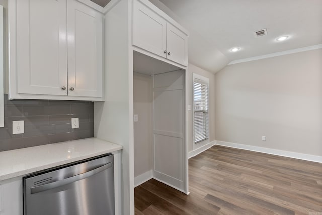 kitchen featuring light stone countertops, white cabinets, lofted ceiling, decorative backsplash, and stainless steel dishwasher