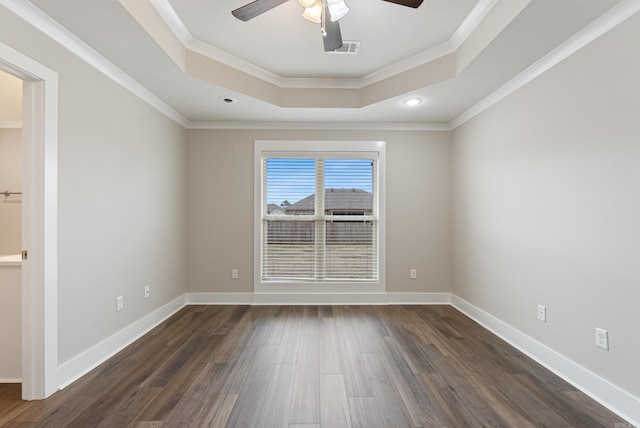 unfurnished room featuring a raised ceiling, ceiling fan, dark wood-type flooring, and crown molding