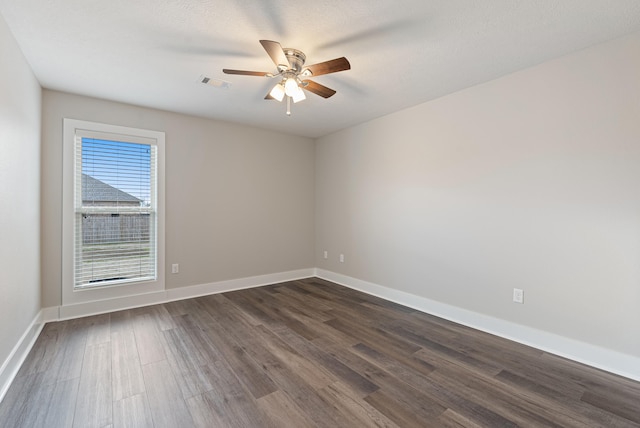 empty room featuring ceiling fan and dark hardwood / wood-style flooring