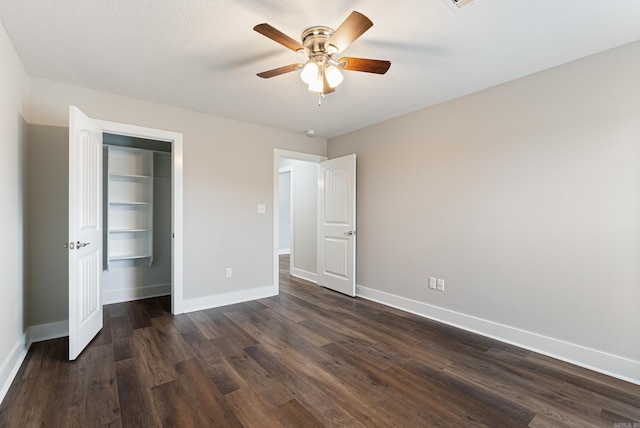 unfurnished bedroom with ceiling fan, dark hardwood / wood-style floors, and a closet