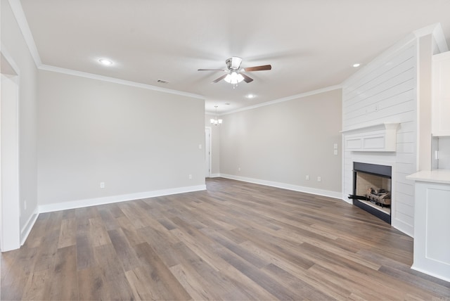 unfurnished living room featuring ceiling fan with notable chandelier, ornamental molding, and hardwood / wood-style flooring