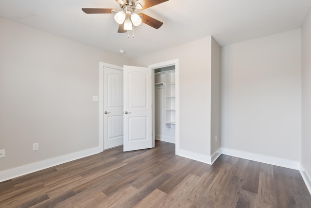 unfurnished bedroom featuring ceiling fan, a closet, and dark wood-type flooring