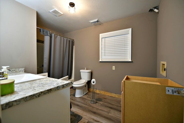 bathroom featuring curtained shower, wood-type flooring, toilet, and vanity