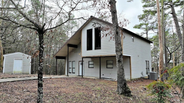 view of front facade featuring central AC unit and a storage unit