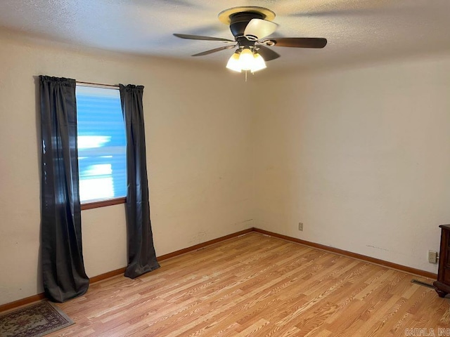 empty room with ceiling fan and light wood-type flooring