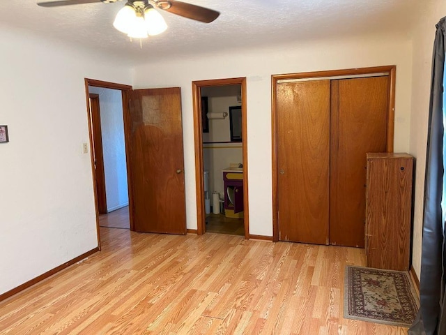 unfurnished bedroom with a textured ceiling, ceiling fan, a closet, and light hardwood / wood-style floors