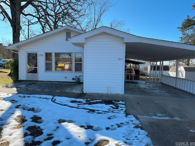 snow covered property with a carport