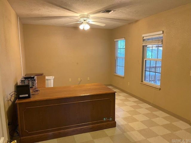 unfurnished office featuring a textured ceiling and ceiling fan