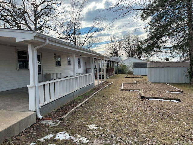 view of yard with a storage shed and covered porch