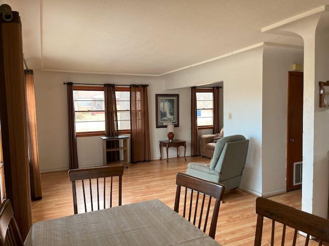 living area with light hardwood / wood-style flooring and crown molding