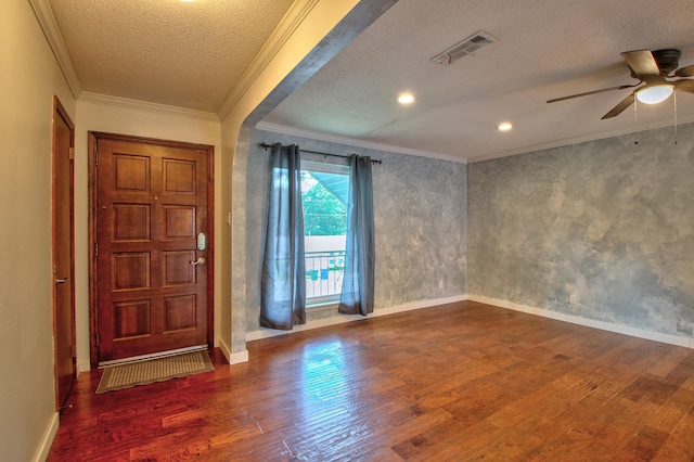 foyer entrance featuring a textured ceiling, ornamental molding, and hardwood / wood-style flooring