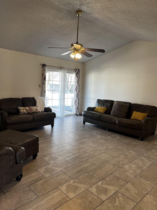 living room featuring ceiling fan, a textured ceiling, and lofted ceiling