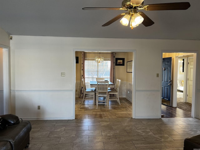 dining area featuring ceiling fan with notable chandelier