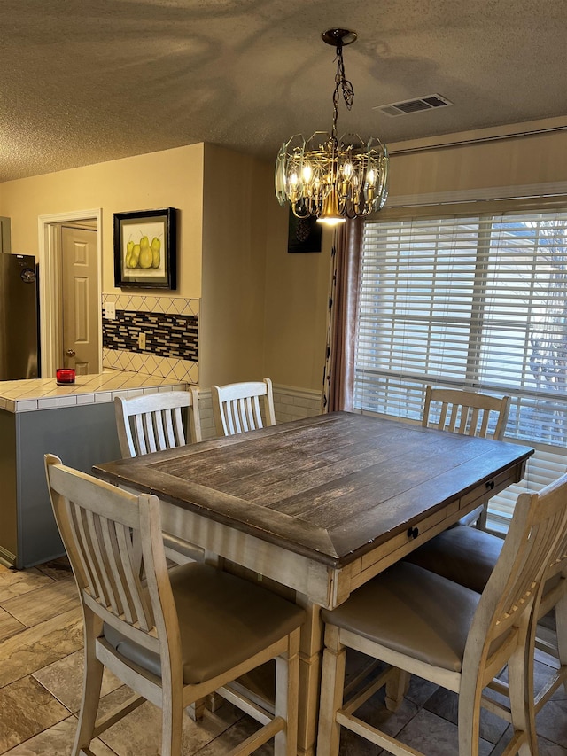 dining room featuring a textured ceiling and an inviting chandelier