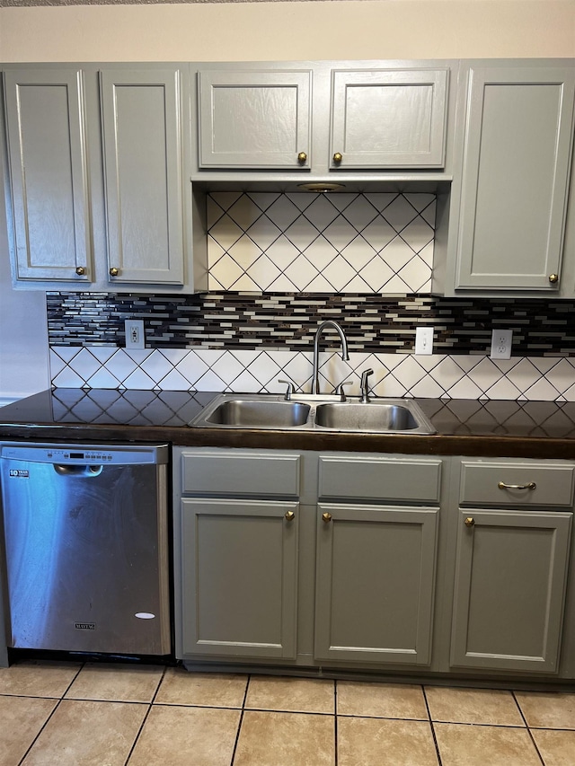 kitchen featuring tasteful backsplash, dishwasher, sink, and gray cabinetry