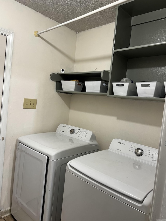 laundry area with a textured ceiling and independent washer and dryer