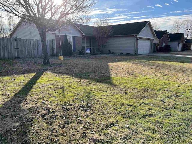 ranch-style house featuring a front yard and a garage