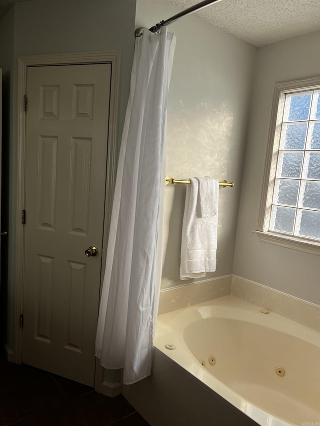 bathroom featuring a textured ceiling and a bathing tub