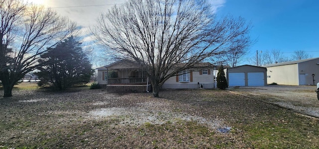 single story home with covered porch, an outdoor structure, and a garage