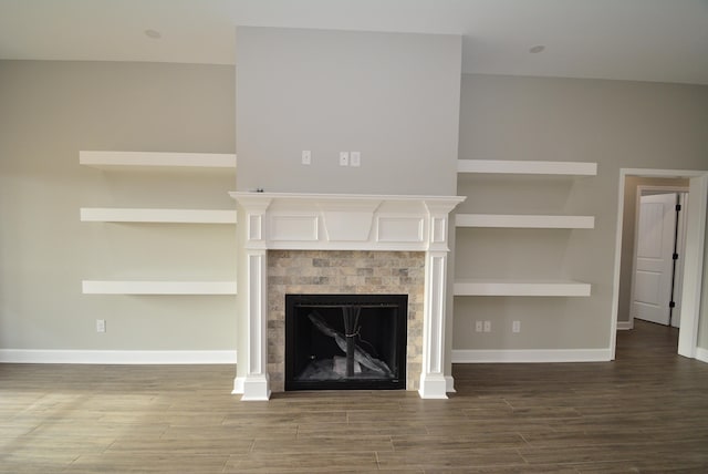 unfurnished living room featuring built in features and a tiled fireplace