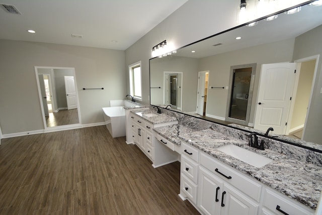 bathroom featuring independent shower and bath, hardwood / wood-style flooring, and vanity