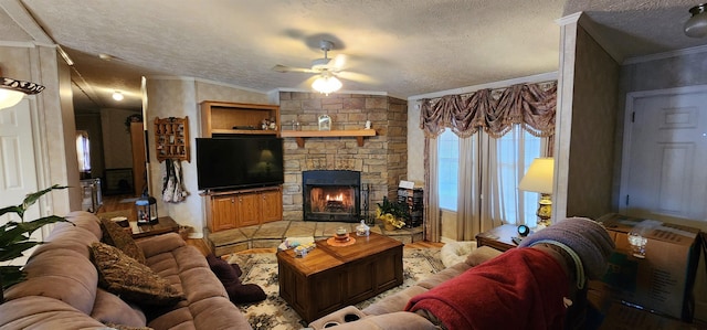 living room with a textured ceiling, ceiling fan, crown molding, and a fireplace