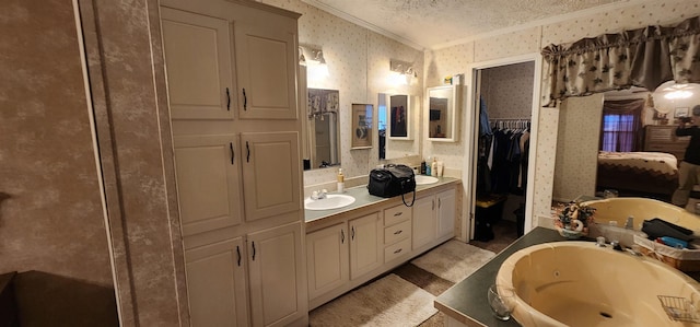 bathroom with a textured ceiling, ornamental molding, a tub to relax in, and vanity