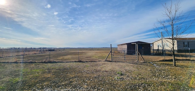 view of yard with a rural view and an outdoor structure