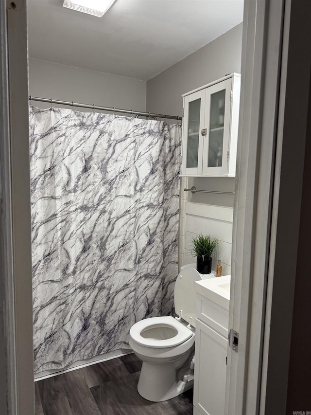 bathroom featuring walk in shower, vanity, toilet, and hardwood / wood-style floors