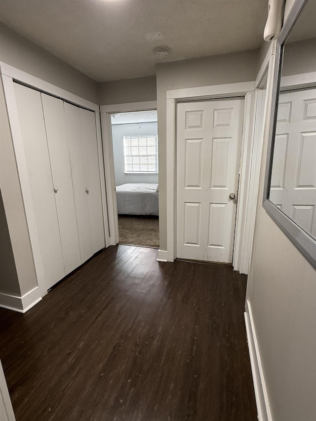 unfurnished bedroom with multiple closets and dark wood-type flooring