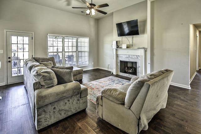 living room featuring dark wood-type flooring, ceiling fan, and a fireplace