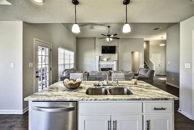 kitchen featuring ceiling fan, sink, hanging light fixtures, light stone countertops, and white cabinets