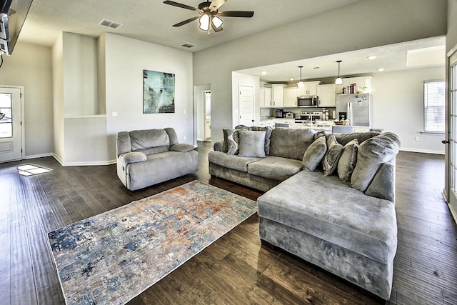 living room with ceiling fan and dark hardwood / wood-style floors