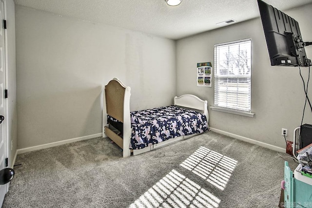 bedroom featuring a textured ceiling and carpet