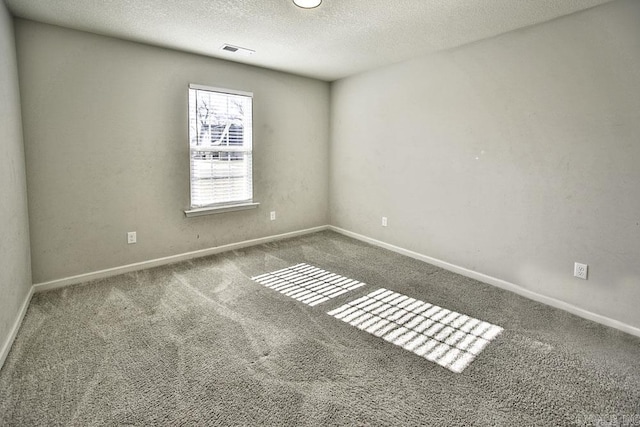 carpeted empty room featuring a textured ceiling