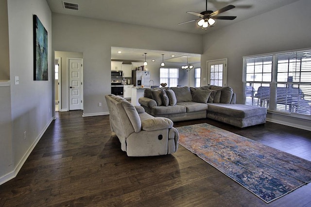 living room featuring dark hardwood / wood-style flooring, sink, and ceiling fan with notable chandelier