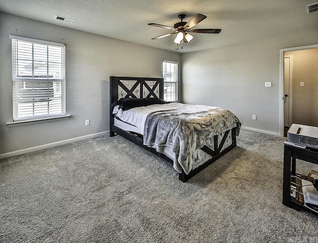 bedroom with ceiling fan, carpet, and a textured ceiling