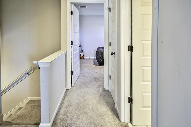 hallway featuring light colored carpet