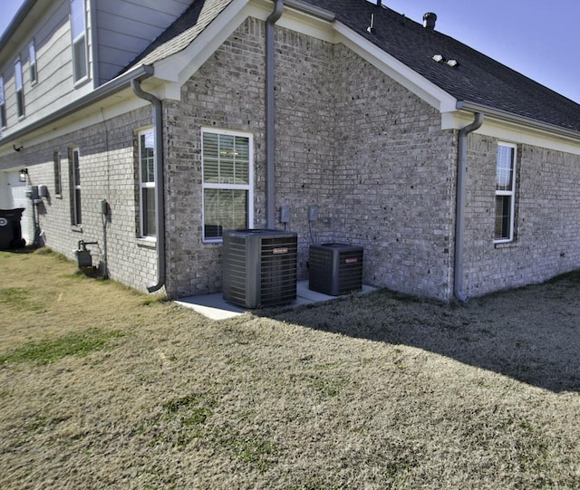 view of home's exterior with cooling unit and a yard