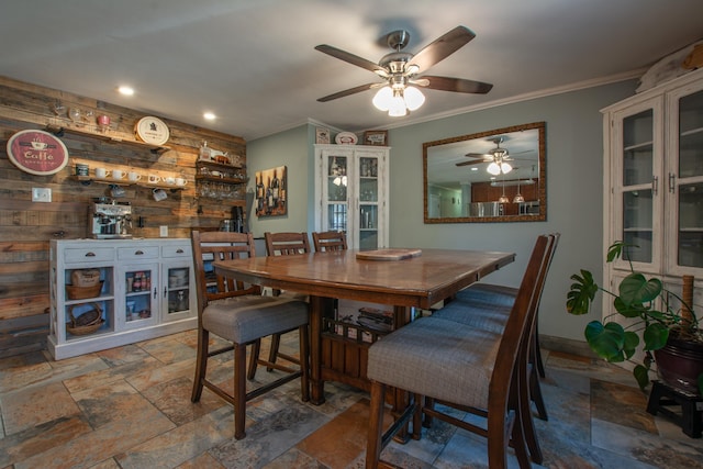 dining area featuring wood walls and crown molding